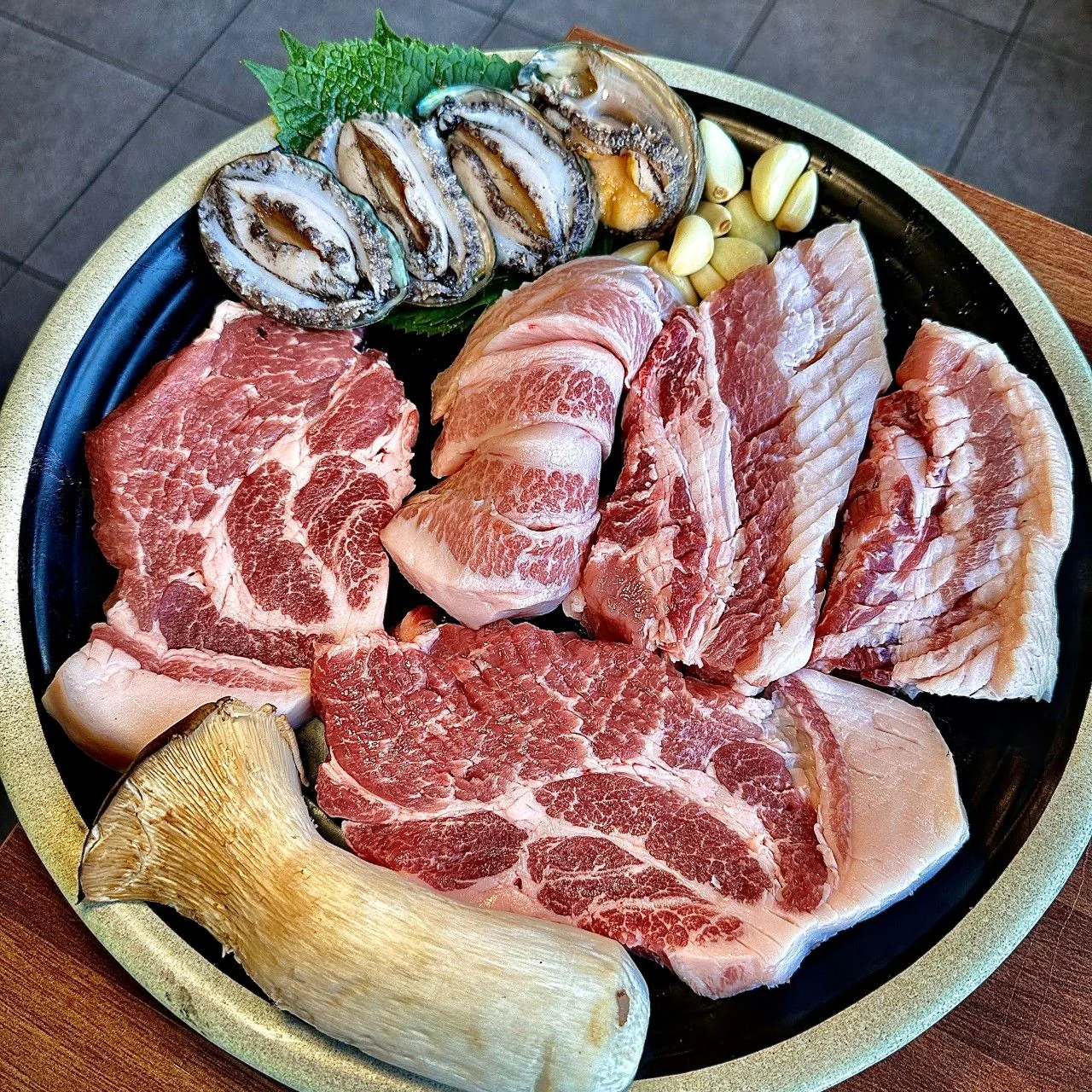 圓盤上的豬肉、鮑魚與杏鮑菇